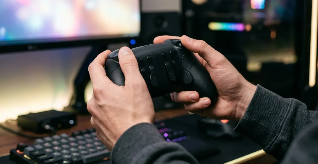 Joueur professionnel utilisant une manette avec palettes arrière dans un environnement de jeu ergonomique
