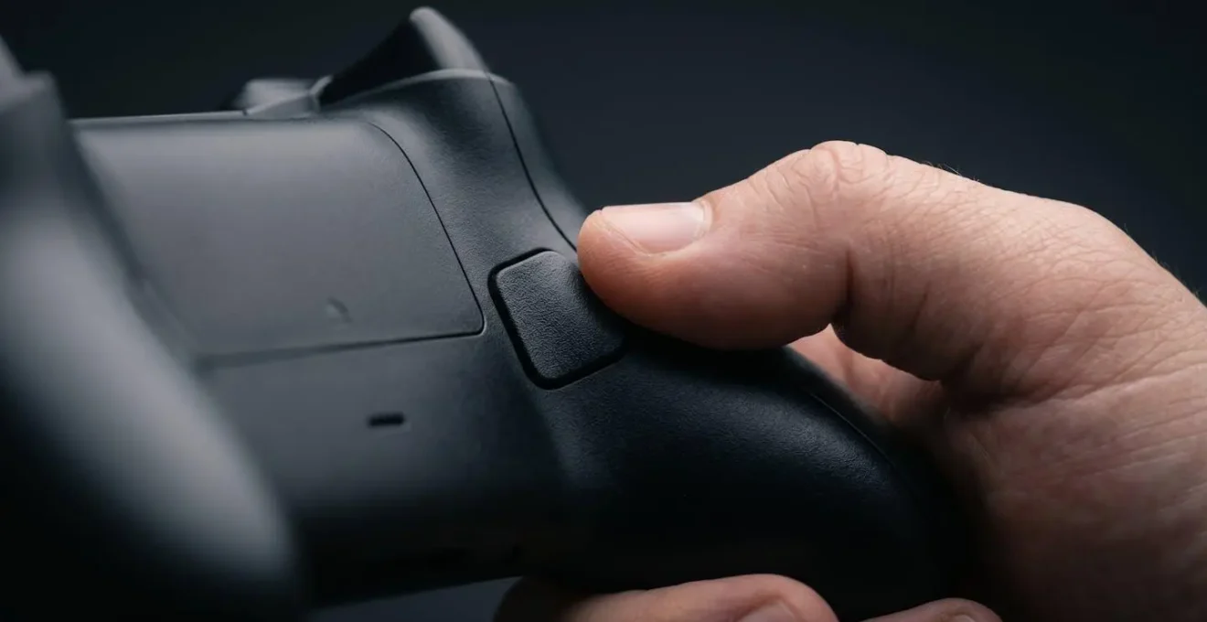 Vue macro des doigts sur les palettes arrière d'une manette gaming